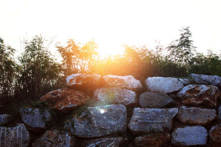 The sun shines down on a stone wall.の写真素材