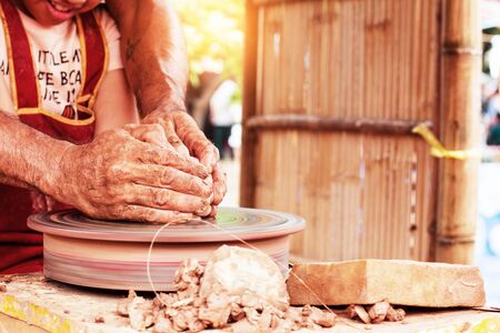 Girls are hand-made pottery in the countryside.