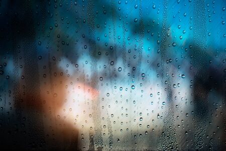 Water drops on glass with light and shadow in rainy season.の写真素材
