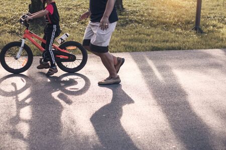 Father and son are cycling in the park.の写真素材