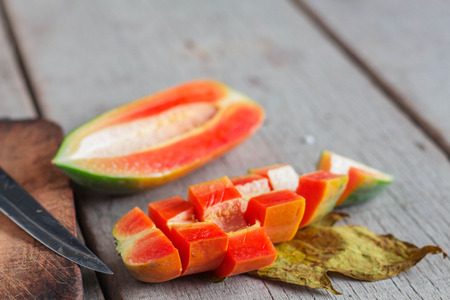 Cut the papaya on the old wooden floor.の写真素材