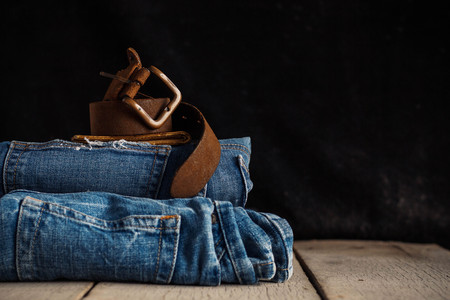 Old leather of belt and jeans on a wooden.の写真素材