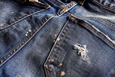The surface of old jeans and a tear on the fabric.の写真素材
