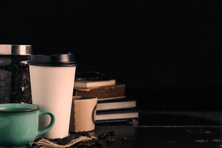 Cup of coffee with books on black background.の写真素材