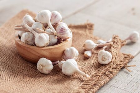 Garlic in a bowl on wooden floor.の写真素材