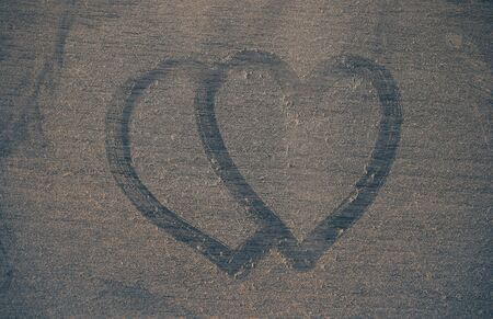 Two hearts on a dusty of wooden floor.の写真素材