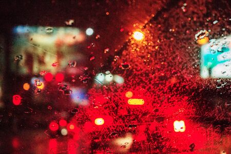 Water droplets on car glass and light at night.の写真素材