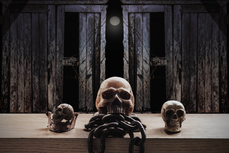 Skulls and chains on old wood and dark at night.の写真素材