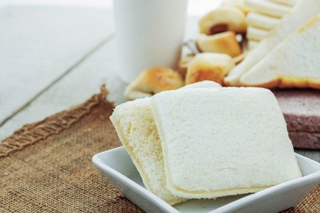 Bread baked in a plate and coffee on table.の写真素材