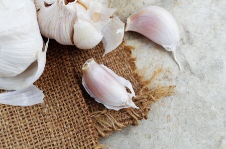 Dry garlic on sack and cement floor.の写真素材