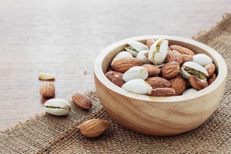 Many almonds in a bowl on sackcloth.の写真素材