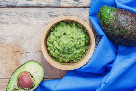 Avocado in a bowl and tablecloth on wooden.の写真素材
