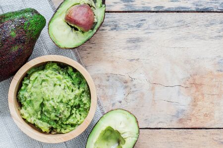 Avocado in a bowl on wooden floor.の写真素材