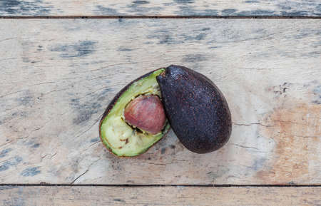 Avocado cut and rot on old wooden floor.の写真素材