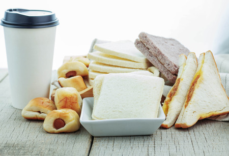breads and coffee cups on wooden floor.