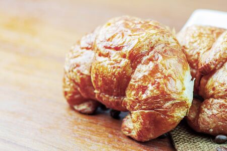 croissants and coffee beans on wooden table.の写真素材