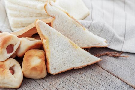 Many breads are laid on wooden boards.の写真素材
