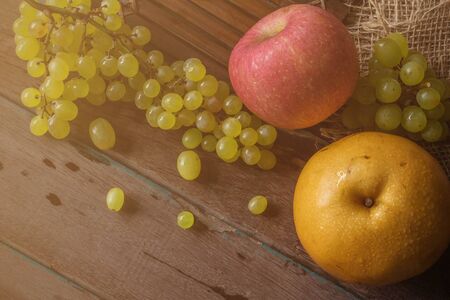 Pear and grapes on old wooden floor.の写真素材