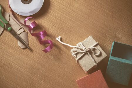 Ribbon and scissors for gift wrapping on a woodenの写真素材