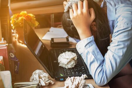 The Girl with stress on the desk at office.の写真素材