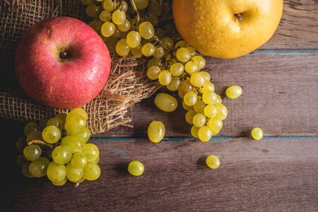 Fresh apples and grapes on a wooden table.の写真素材