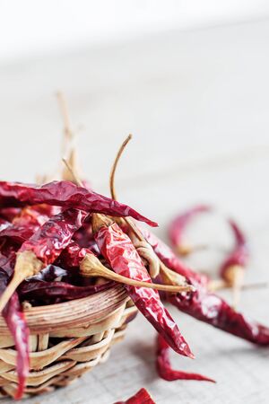 Dried chilly in bowl on wooden with a white background.の写真素材