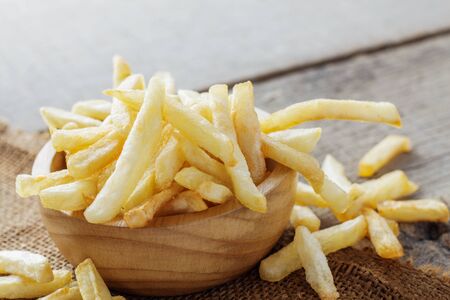 French fries in a bowl on wooden floor.の写真素材