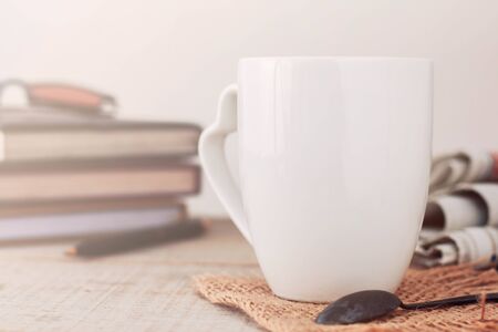 White coffee cup and book on wooden table.の写真素材