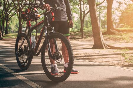 Cyclists with bikes on street in the park with sun shining.の写真素材