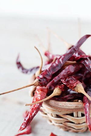 Dried chilly in a bowl on wooden floor.の写真素材