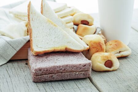 Many breads on tray and wooden floor.の写真素材