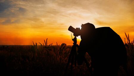 Photographers in meadow and the sky with silhouette.の写真素材