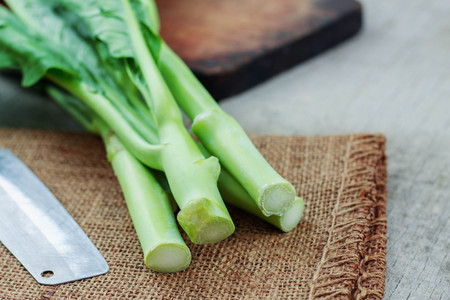 Fresh kale and knife for cooking on wooden floor.の写真素材