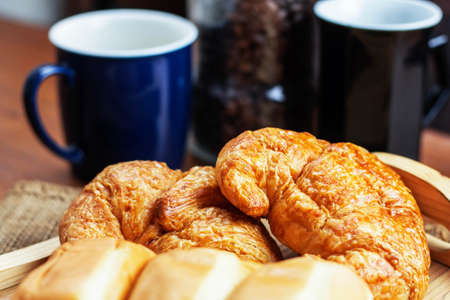 Bread on wooden tray and coffee cup.の写真素材