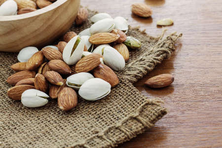Dried almonds on sackcloth and a bowl.の写真素材