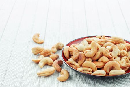Cashew nuts roasted salt on a plate with white background.の写真素材