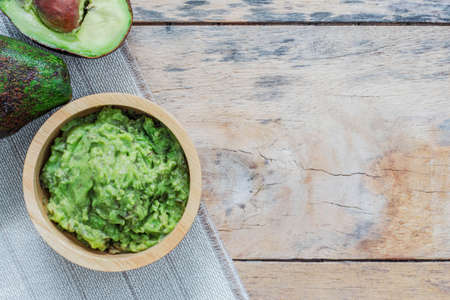 Grated avocado in a bowl on wooden floor.の写真素材