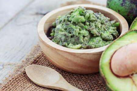 Grated avocado in bowl and spoon on sackcloth.の写真素材