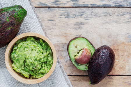 Grated avocado in a bowl on wooden table.の写真素材