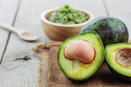 half avocado and green on the wooden table.の写真素材