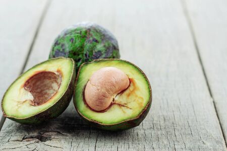 half of avocado and green on the old wooden floor.の写真素材