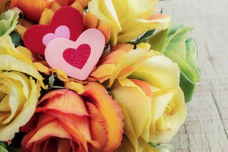 Two hearts on rose with a wooden background.の写真素材