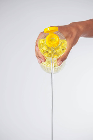 Hand is pouring vegetable oil for cooking.の写真素材