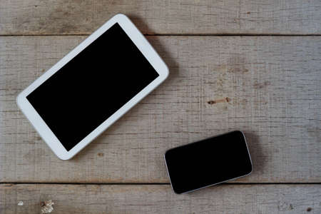 Tablets and cell phones on the old wooden floor.の写真素材