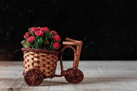 Roses in a basket on the old wooden floor.の写真素材