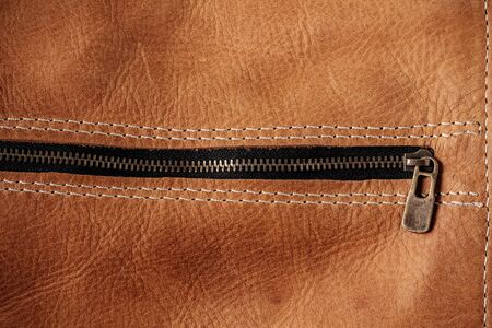 surface of old brown leather and zipper.の写真素材