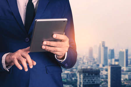 Young businessman with a tablet in town of society.の写真素材