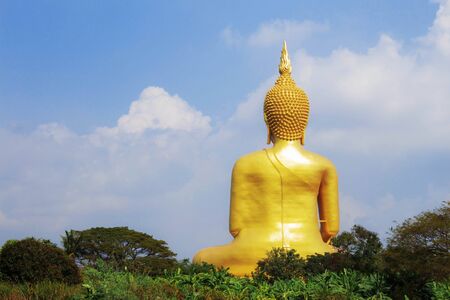 Golden Buddha on the field with blue sky.の写真素材