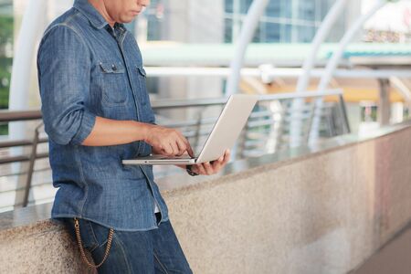 Young man holding notebook working in the city.の写真素材