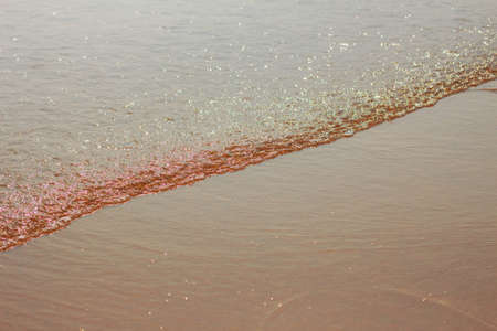 Sea waves with the sunrise at sand beach.の写真素材